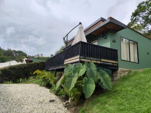 uma casa verde com uma varanda em cima em Hotel Alma Verde em Chiquinquirá