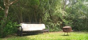 a couch sitting in the grass next to a tree at Morocha in Estación Costa Azul