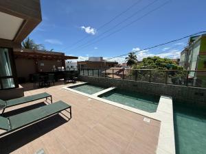 a balcony with a swimming pool on top of a building at Flat 1 quarto Beach Porto - By Duuna Temporada in Porto De Galinhas