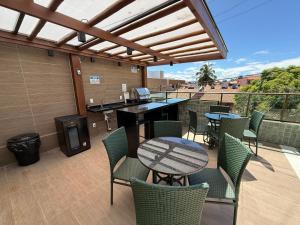 a patio with a table and chairs and a grill at Flat 1 quarto Beach Porto - By Duuna Temporada in Porto De Galinhas