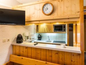 eine Küche mit einer Uhr an der Wand in der Unterkunft Appartement 6 pers Les Arcs 1800 avec balcon et accès wifi - FR-1-346-403 in Arc 1800 + 19 Fotos
