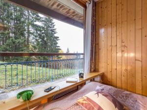 Zimmer mit einem großen Fenster mit einem Bett und einer Fensterbank in der Unterkunft Appartement 6 pers Les Arcs 1800 avec balcon et accès wifi - FR-1-346-403 in Arc 1800
