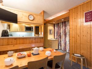 ein Esszimmer mit Tisch und eine Küche in der Unterkunft Appartement 6 pers Les Arcs 1800 avec balcon et accès wifi - FR-1-346-403 in Arc 1800