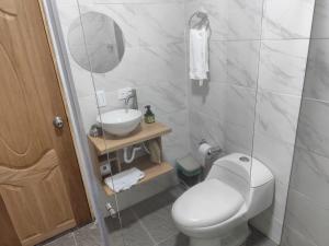 um banheiro com um vaso sanitário branco e uma pia em Hotel Alma Verde em Chiquinquirá mais 7 fotografias