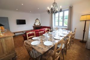 a dining room with a long table and chairs at L'Oustal de Salers in Salers