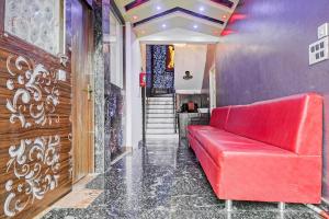 a red couch in a room with a staircase at Hotel O CeeRock in Bhopal