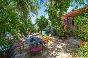 a patio with a table and chairs in front of a house at Zen Beach House, Steps From Atlantic Ave And Beach in Delray Beach