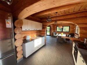 una cucina e una sala da pranzo di una baita di tronchi di Oasis Chalet a Lisnău