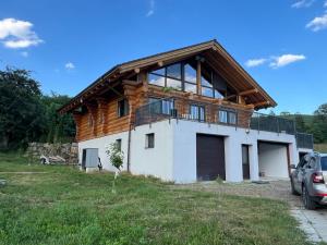 a house with a wooden roof on top of it at Oasis Chalet in Lisnău
