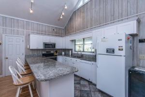 a kitchen with white cabinets and a white refrigerator at Crowfield in Edisto Beach