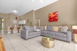 een woonkamer met een bank en een tafel bij Summer Getaway - 5-Bedroom Home with Private Pool! in Kissimmee