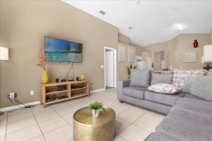 een woonkamer met een bank en een tv bij Summer Getaway - 5-Bedroom Home with Private Pool! in Kissimmee