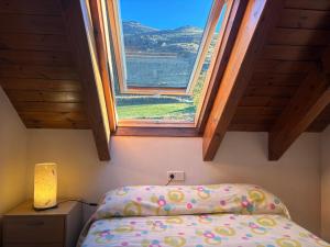 un dormitorio con una cama y una ventana en Cocina moderna, bajo cubierta rústico- Comodidad máxima - Erta 3, en Pla de l'Ermita