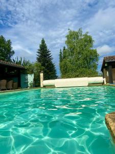 a swimming pool with turquoise water at le bon chemin roulotte in Sainte-Nathalène