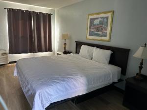 een slaapkamer met een groot wit bed in een kamer bij Lakeview Inn in Lake Saint Louis +1 foto