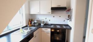 Una pequeña cocina con fregadero y estufa. en Birkmaase 14 - Komfort FeWo im 4-Sterne-Ferienhaus Anselm DG, en Zingst