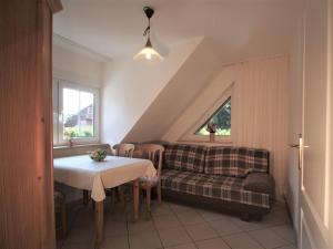 una sala de estar con una mesa y un sofá en Birkmaase 14 - Komfort FeWo im 4-Sterne-Ferienhaus Anselm DG, en Zingst
