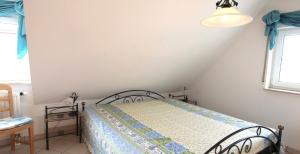 Un dormitorio con una cama y una ventana en Birkmaase 14 - Komfort FeWo im 4-Sterne-Ferienhaus Anselm DG, en Zingst 4 fotos más