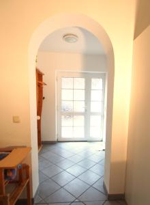 un arco que conduce a una habitación con puerta en Birkmaase 16 - Komfort FeWo im 4-Sterne-Ferienhaus Manuela EG, en Zingst