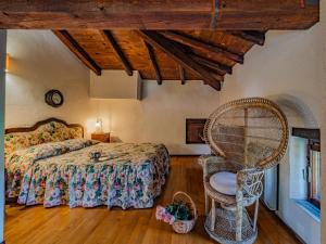 ein Schlafzimmer mit einem Bett und einem Stuhl in der Unterkunft La Torre della Casaforte Bergum alle porte di Cividale del Friuli in Cividale del Friuli