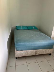 a bed in a room with blue pillows on it at Pousada Metropolitana Salvador in Candeias +10 photos