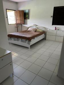 a bedroom with a bed and a tiled floor at Pousada Metropolitana Salvador in Candeias