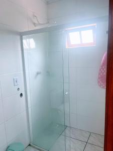 a bathroom with a shower with a glass door at Bombinhas, Casa mobiliada 1 quarto in Bombinhas