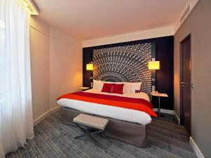 een hotelkamer met een groot bed met rode kussens bij Mercure Nantes Centre Grand Hotel in Nantes