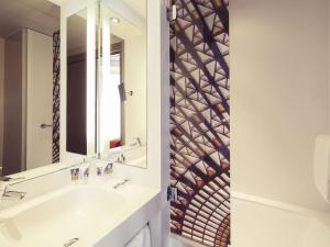 een badkamer met een wastafel en een spiegel bij Mercure Nantes Centre Grand Hotel in Nantes +83 foto's
