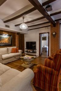 ein Wohnzimmer mit Sofa, Sesseln und Fernseher in der Unterkunft Inmyhome Country House Monachil in Granada