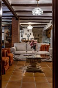 ein Wohnzimmer mit einer Couch und einem Tisch mit Blumen in der Unterkunft Inmyhome Country House Monachil in Granada