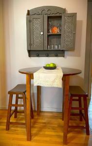 Una mesa de madera con dos taburetes y un armario. en Bluffside Chalet Suite, en McGregor