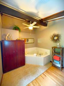 baño grande con bañera y ventilador de techo. en Bluffside Chalet Suite, en McGregor