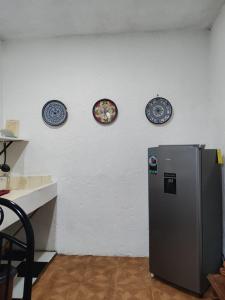 Un refrigerador en una cocina con tres platos en la pared en Abuelita, en Santa María Tonantzintla 2 fotos más