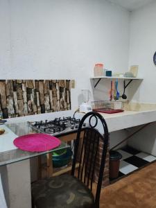 una cocina con fogones y una mesa con una silla en Abuelita, en Santa María Tonantzintla