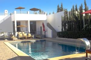 a swimming pool in front of a house at Dar naima in Al Ghar