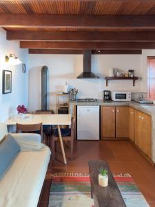 eine Küche mit Tisch und Esszimmer in der Unterkunft Casa da Manta - Palheiro in Fajã da Ovelha + 11 Fotos
