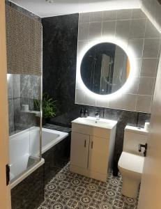 a bathroom with a sink and a toilet and a mirror at 60 Springfield Road in Stornoway