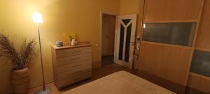 a bedroom with a bed and a dresser and a lamp at Ruola in Kaunas