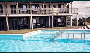 a large swimming pool in front of a building at Apartament KOJA in Rewal +6 photos