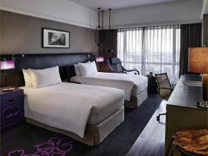 a hotel room with two beds and a desk at Sofitel Saigon Plaza in Ho Chi Minh City