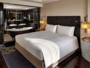 a bedroom with a large bed and a bath tub at Sofitel Saigon Plaza in Ho Chi Minh City
