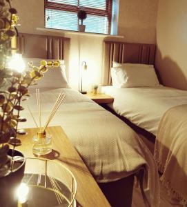 a hotel room with two beds and a table with a table sidx sidx at Rooms at the Village in Omagh