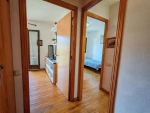 einen Flur mit einer Tür, die zu einem Schlafzimmer führt in der Unterkunft Ambiente cálido y luminoso- Confort rústico - Falcó 5 in Pla de l'Ermita