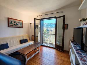 ein Wohnzimmer mit Sofa und Fernseher in der Unterkunft Ambiente cálido y luminoso- Confort rústico - Falcó 5 in Pla de l'Ermita