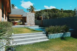 ein Haus mit einer Treppe, die zu einem Swimmingpool führt in der Unterkunft Casa em Milagres| 3 suítes, área gourmet, piscina in Passo de Camarajibe