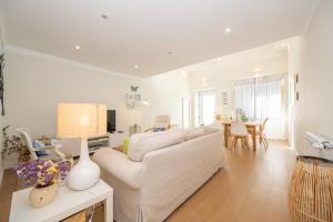 a living room with a white couch and a table at Casa Alecrim in Tavira