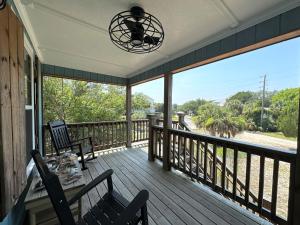 a porch with a table and chairs and a view of the ocean at Serenity Now in Edisto Island