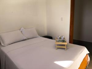 フランカにあるApartamento Familiar com Charme Espaçoso 2VGのサイドテーブル付きの部屋のベッド1台