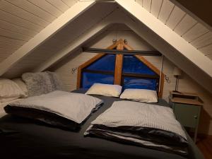 two beds in a room with a large window at Cheerful forest cabin Fireplace and Hot tub in Akranes